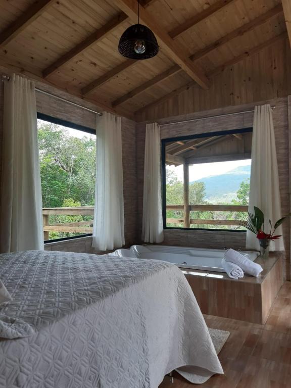 a bedroom with a bed and a large window at Portal da alvorada in Praia Grande