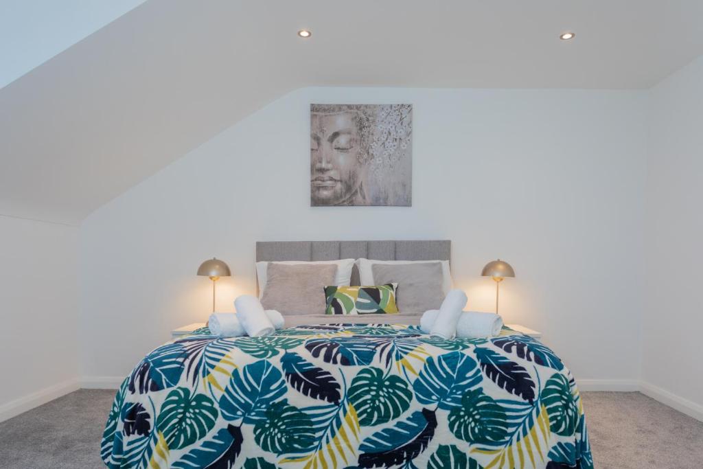 um quarto com uma cama grande e uma colcha colorida em The Arches New Modern 2BR em Belfast