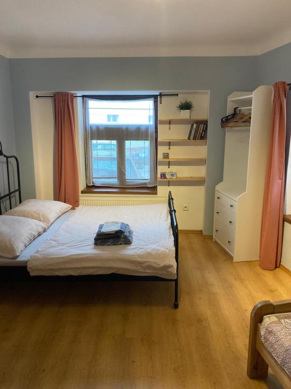 ein kleines Schlafzimmer mit einem Bett und einem Fenster in der Unterkunft Apartman Centrum in Jičín