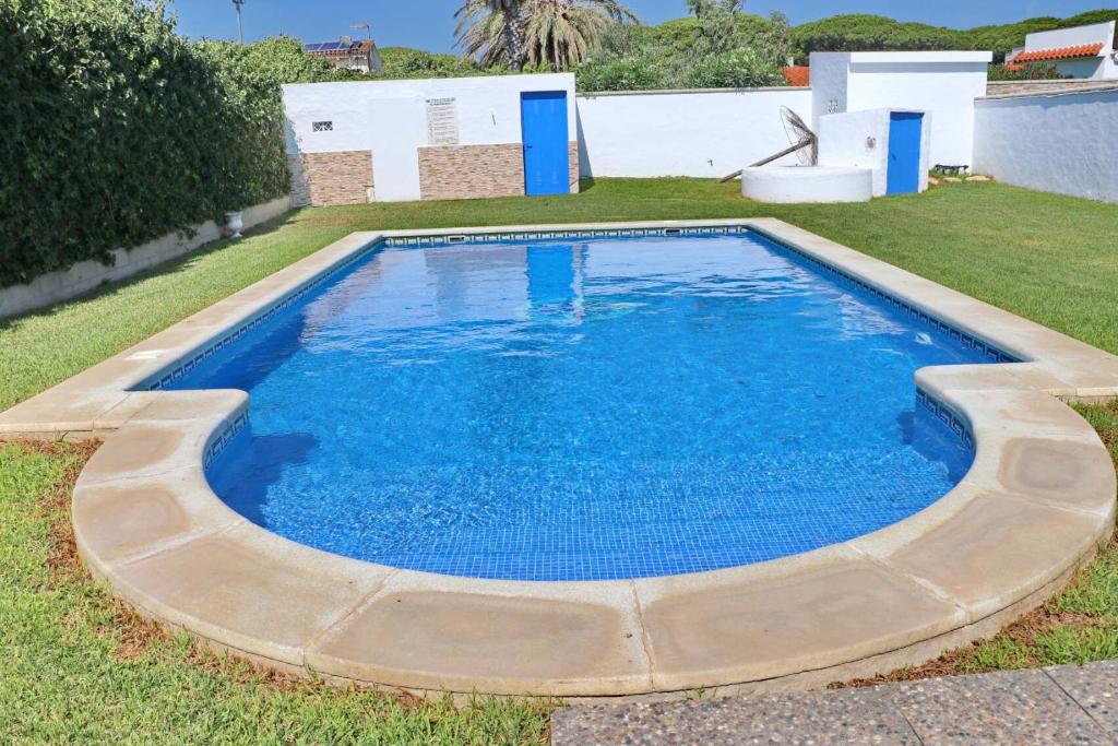 ein großer Pool in einem Hof mit blauem Wasser in der Unterkunft Chalet Cortijo 31 in Conil de la Frontera