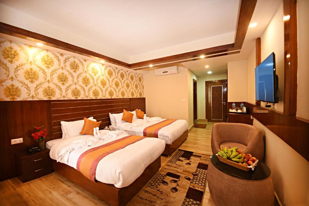 a hotel room with two beds and a television at Hotel Simal in Kathmandu