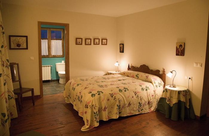 Un dormitorio con una cama y un baño. en Hotel Rural La Peregrina, en Carucedo