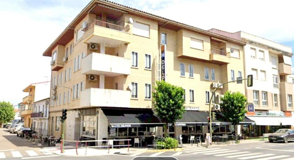 un gran edificio en una calle de la ciudad con un semáforo en Hotel Delphos, en Moraleja