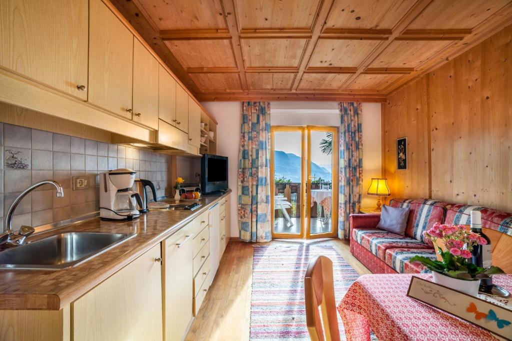 uma cozinha e uma sala de estar com um sofá em Adang Ferienwohnung Etschtal em Tirolo