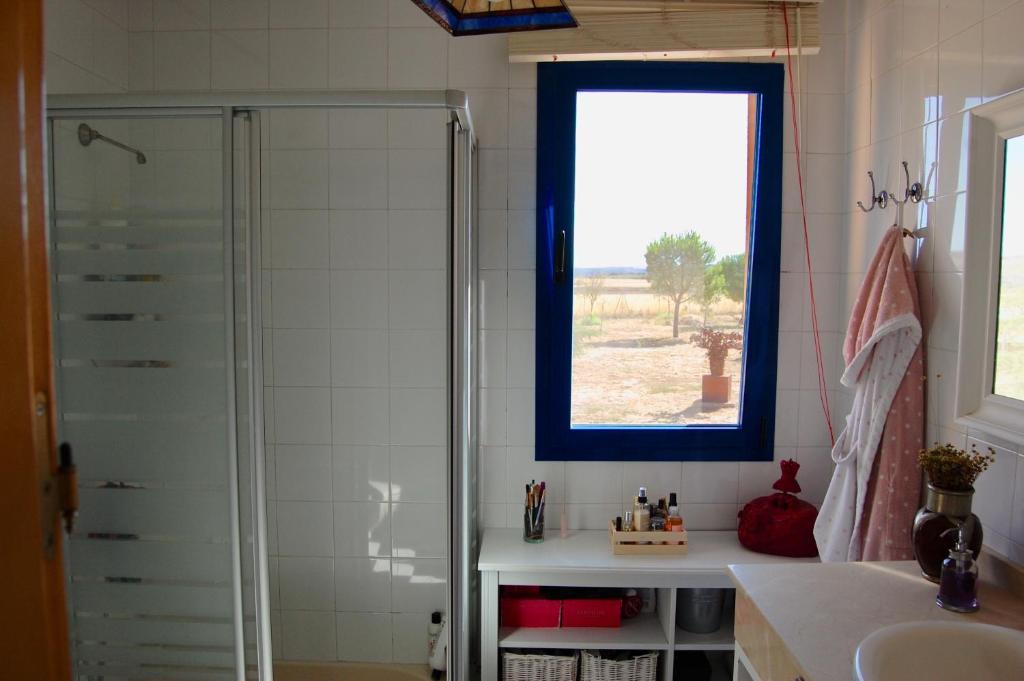 a bathroom with a shower and a sink and a window at 4 bedrooms villa with private pool furnished garden and wifi at Uceda in Uceda