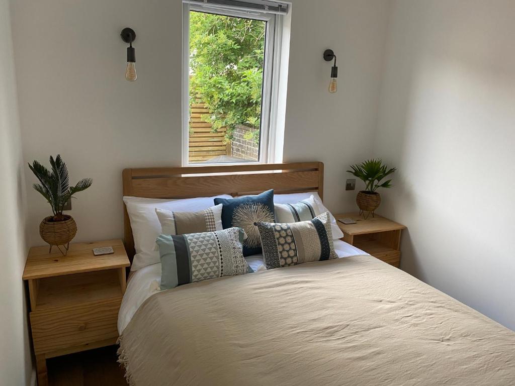 um quarto com uma cama com almofadas e uma janela em Old Town Oasis em Eastbourne