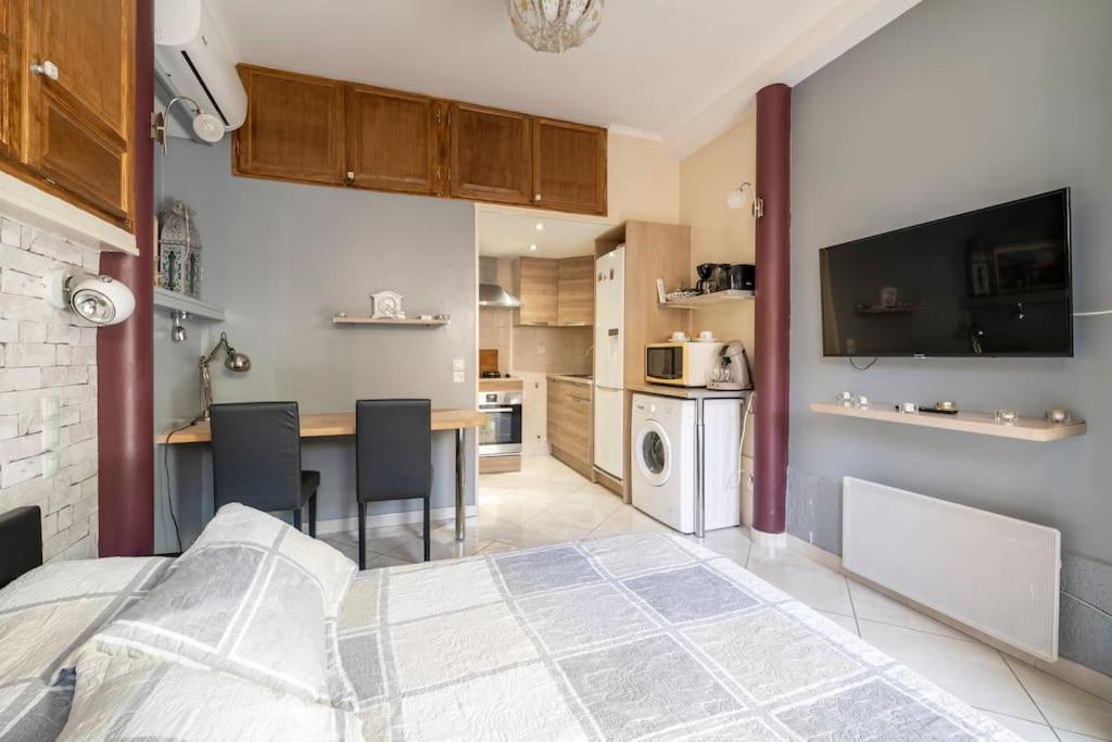 1 dormitorio con 1 cama y cocina con mesa en Studio idéal pour deux voyageurs sur Marseille en Marsella