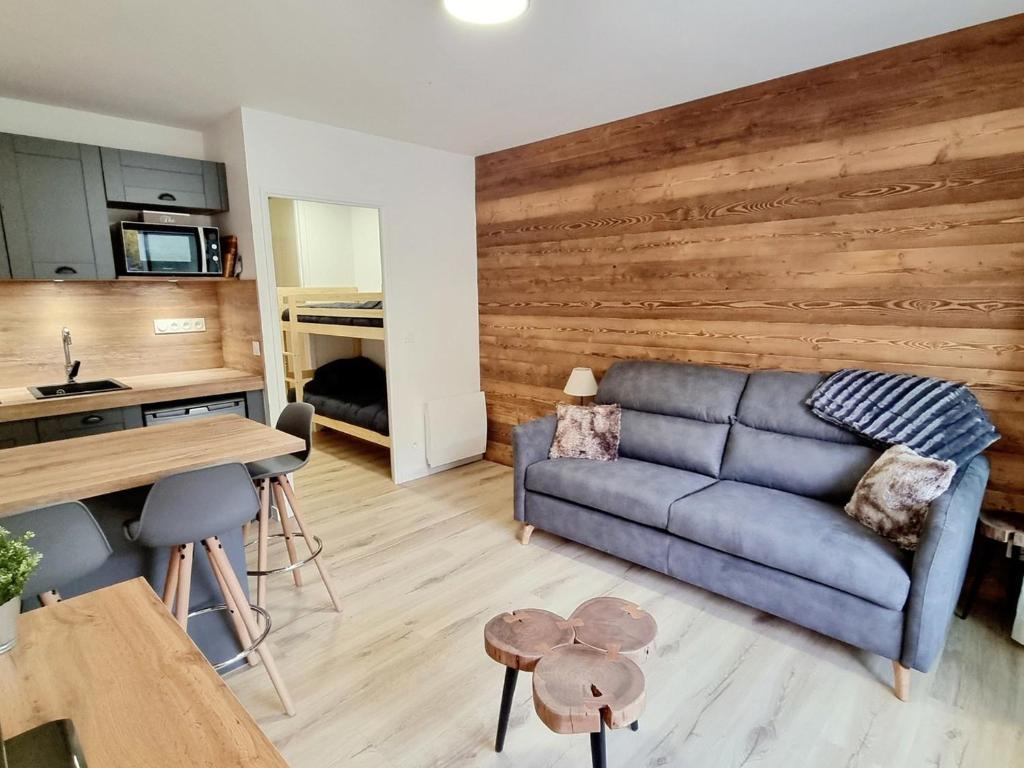 salon z niebieską kanapą i drewnianą ścianą w obiekcie Studio Rénové 4 Pers. au Pied des Pistes avec Parking Gratuit - Résidence Les Fontettes, La Joue du Loup - FR-1-504-646 w mieście Dévoluy