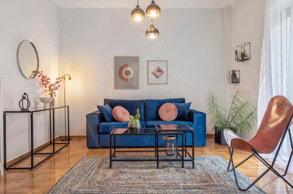 a living room with a blue couch and a table at Luxury 2 bdroom apt- Megaro Mousikis in Athens