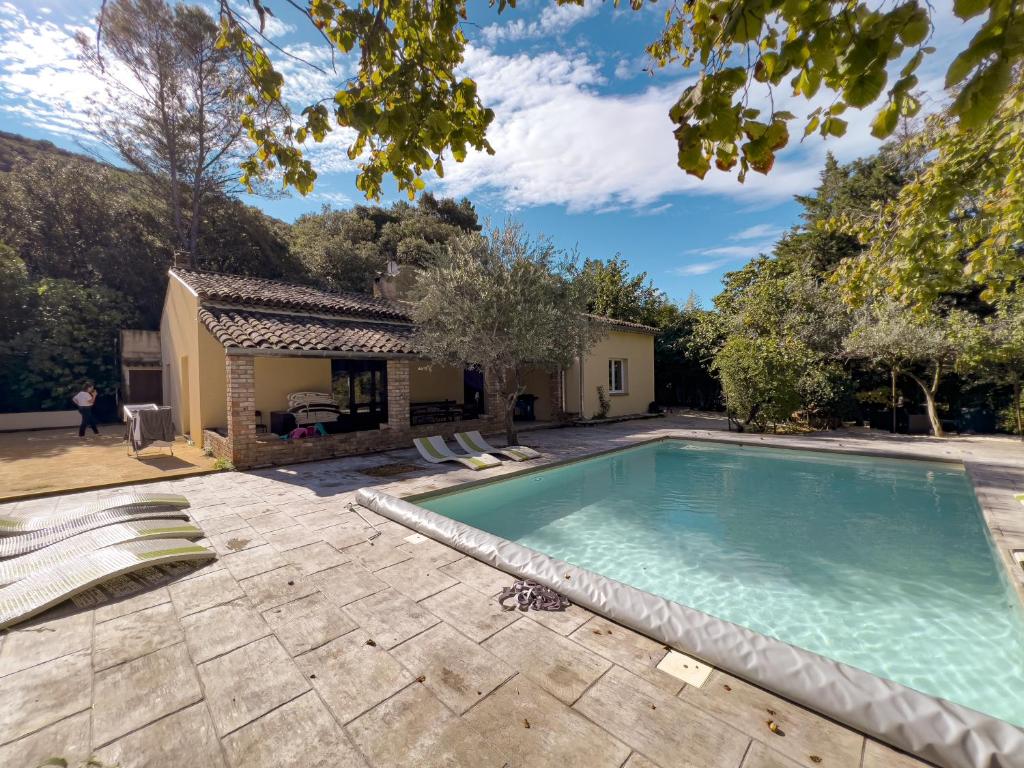 a swimming pool in front of a house at Demeure du Dragon 5 chambres Piscine- 10 lits - personnes in Saint Jean du Pin