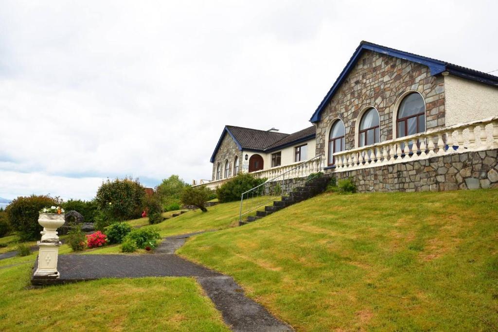 duży kamienny dom z trawnikiem w obiekcie Beautiful House on Wild Atlantic Way - 6 bedrooms w mieście Kenmare