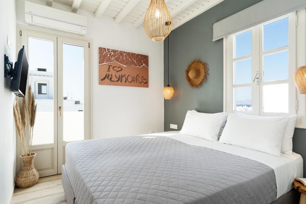 um quarto com uma cama grande e almofadas brancas em Haka Suites Mykonos Town em Míconos