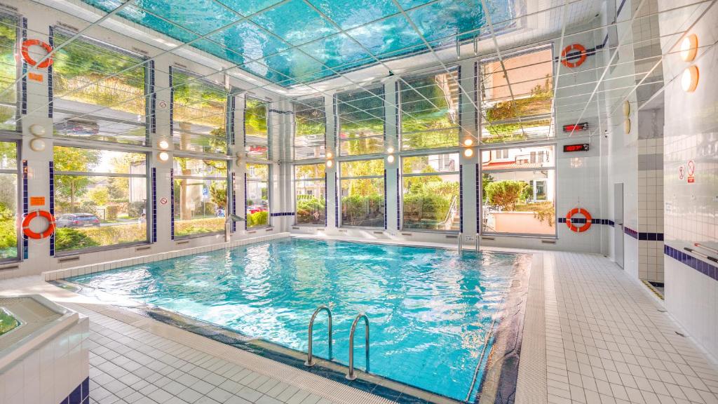 una gran piscina en un edificio con ventanas en Apartamenty Sun & Snow Olymp z basenem, en Kołobrzeg