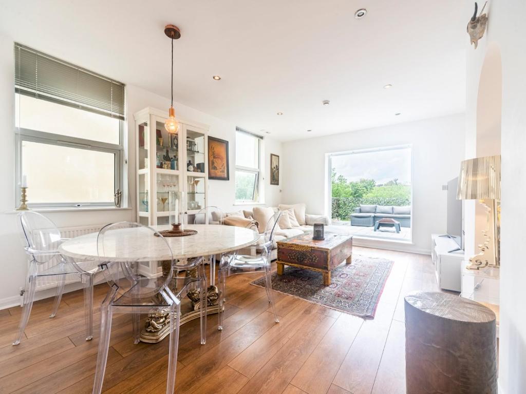 uma sala de jantar e sala de estar com mesa e cadeiras em Pass the Keys Luxurious Flat with Large Private Terrace em Hanworth