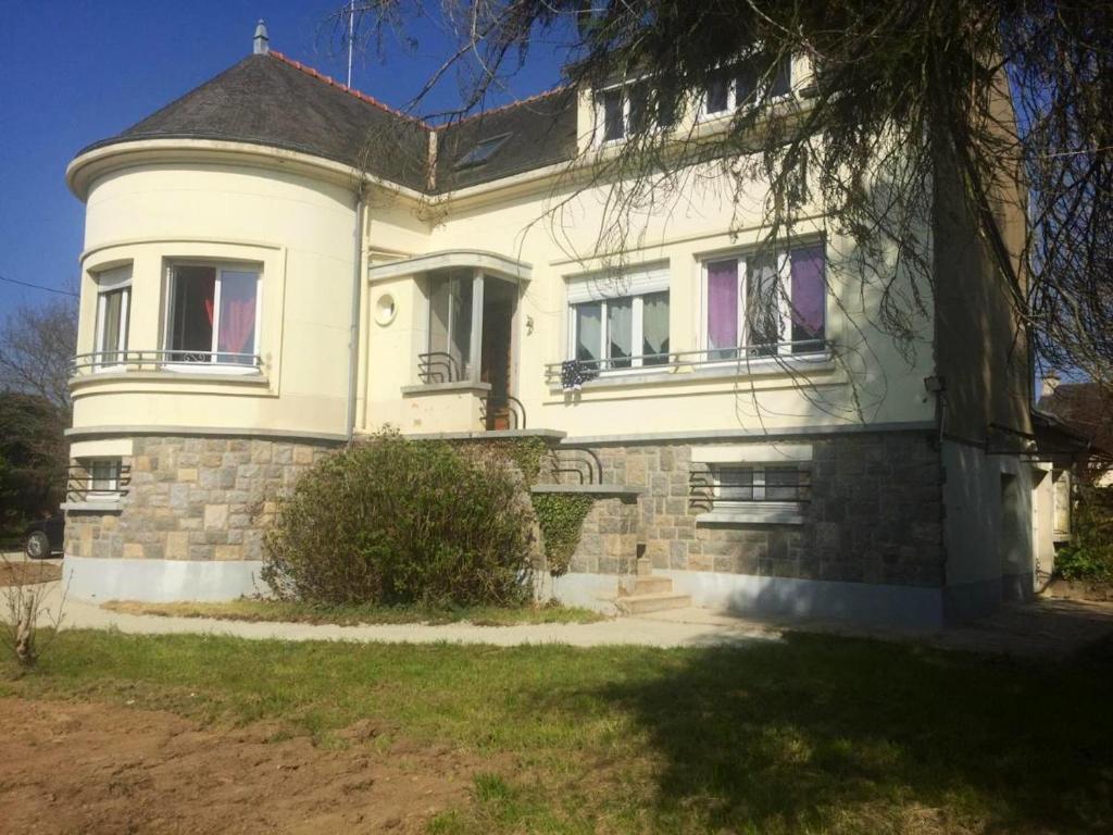 ein großes weißes Haus mit einer Veranda und Fenstern in der Unterkunft Maison de 3 chambres avec jardin clos a Val d'Oust in La Chapelle-Caro