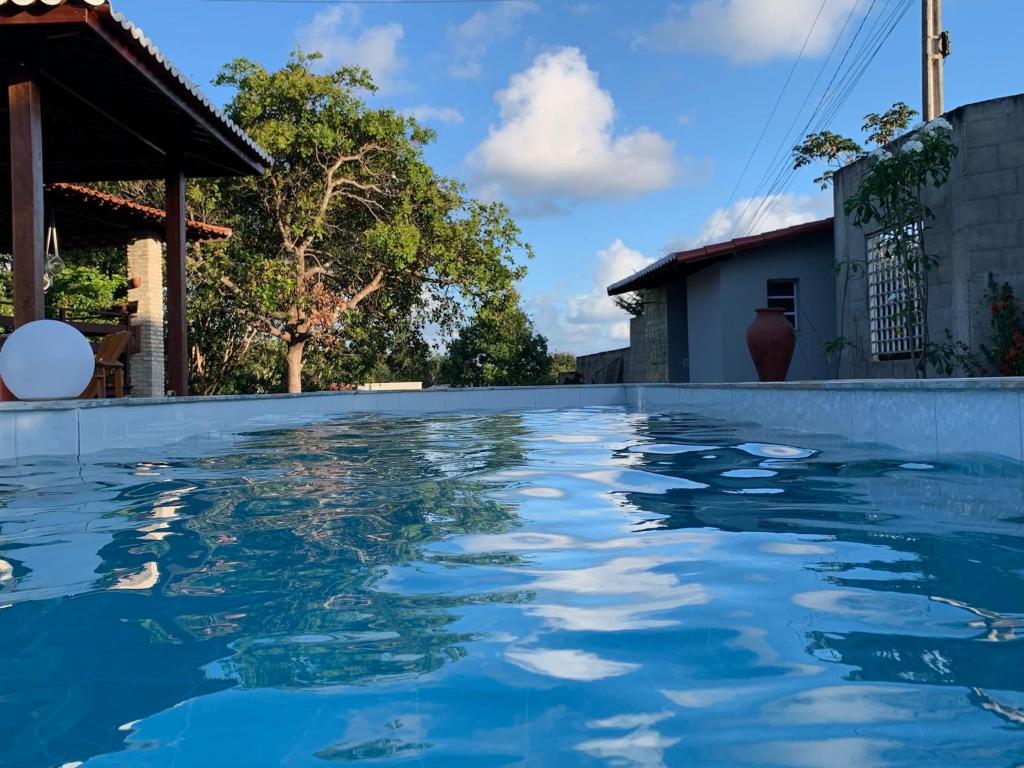 a swimming pool in front of a house at Chalés Tucano Praia da Pipa - Natureza, Conforto, Tranquilidade in Pipa