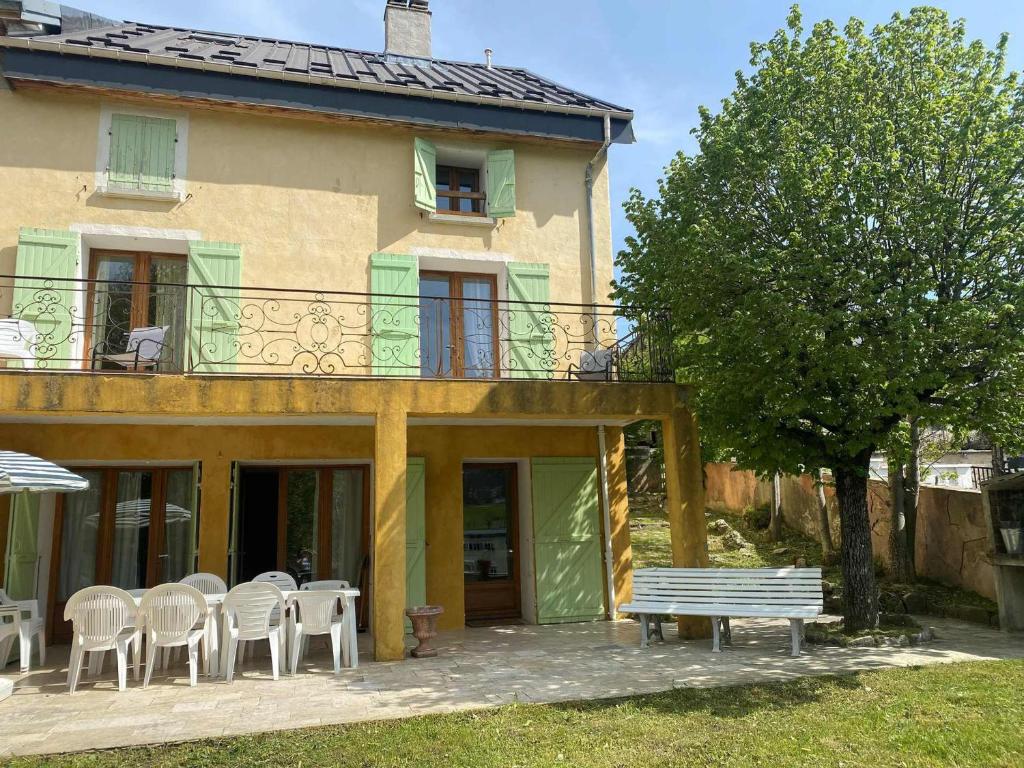 une maison avec des chaises et un banc devant elle dans l'établissement Maison Villard-de-Lans, 6 pièces, 10 personnes - FR-1-515-4, à Villard-de-Lans