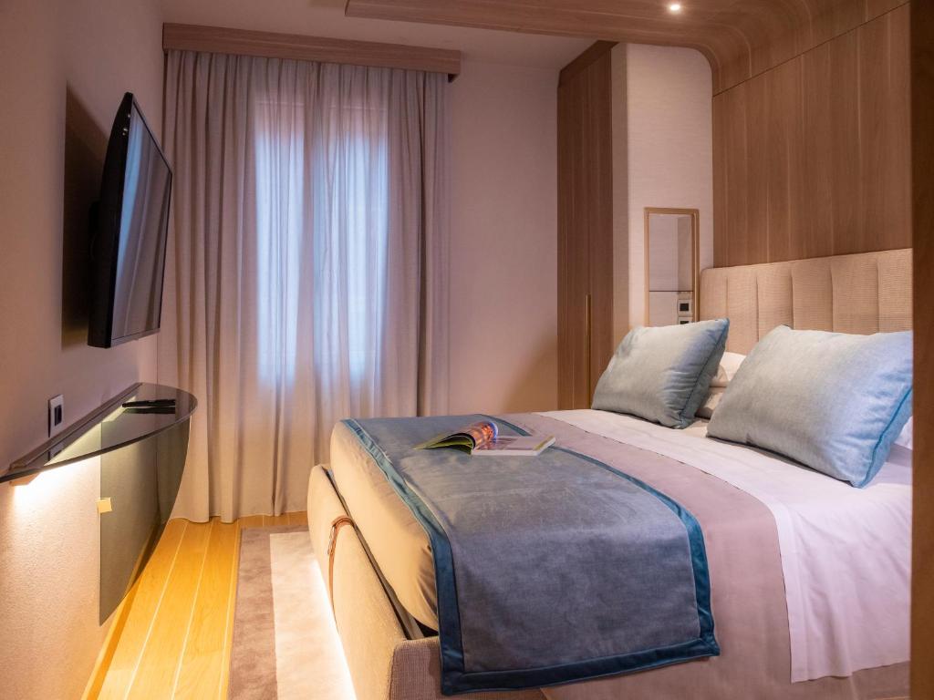 a hotel room with a bed and a flat screen tv at Miramare Suites in Sestri Levante