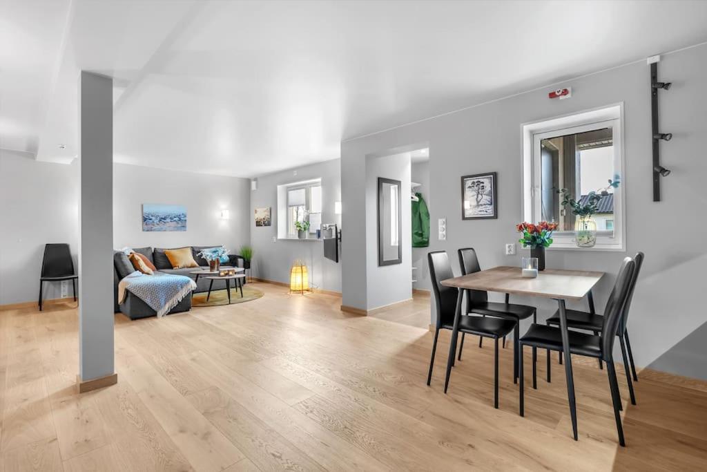 un soggiorno con tavolo, sedie e divano di Modern easy-living apartment in nice neighborhood a Tromsø