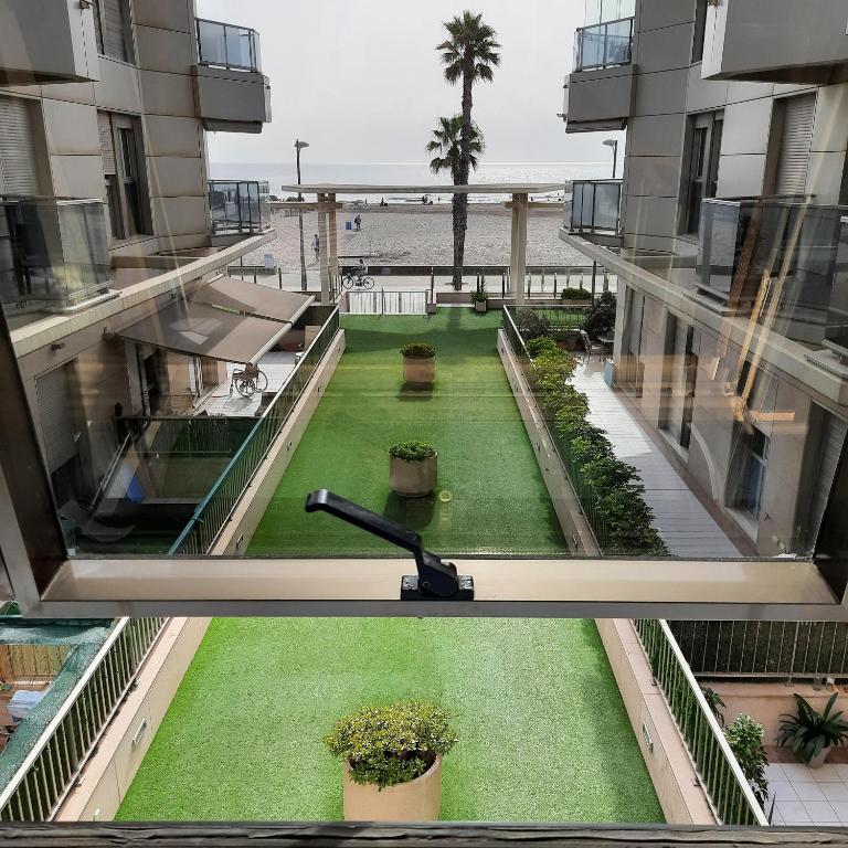 a view from the balcony of a building with a yard at FiveStepsToSea - Beach Apartment Valencia in Valencia