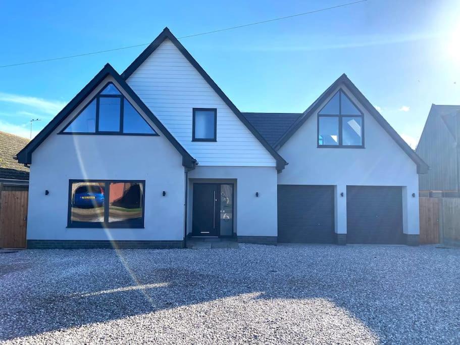 a large white house with a driveway at Brand New, Stunning Beachside House in Seasalter