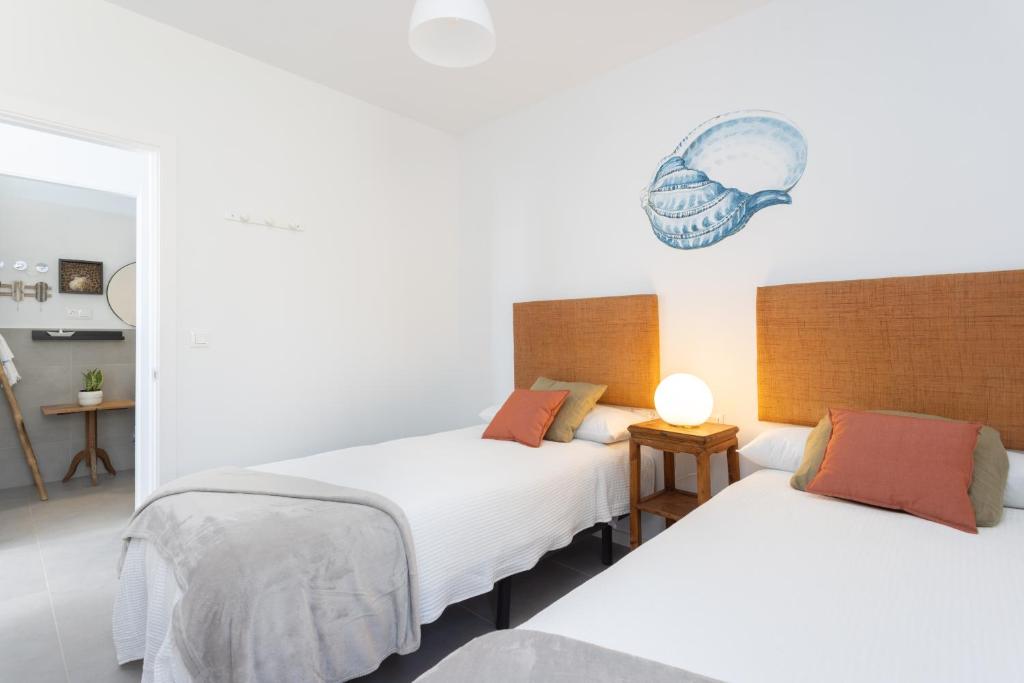 A bed or beds in a room at Home2Book Design & Breathtaking Sea Views El Porís