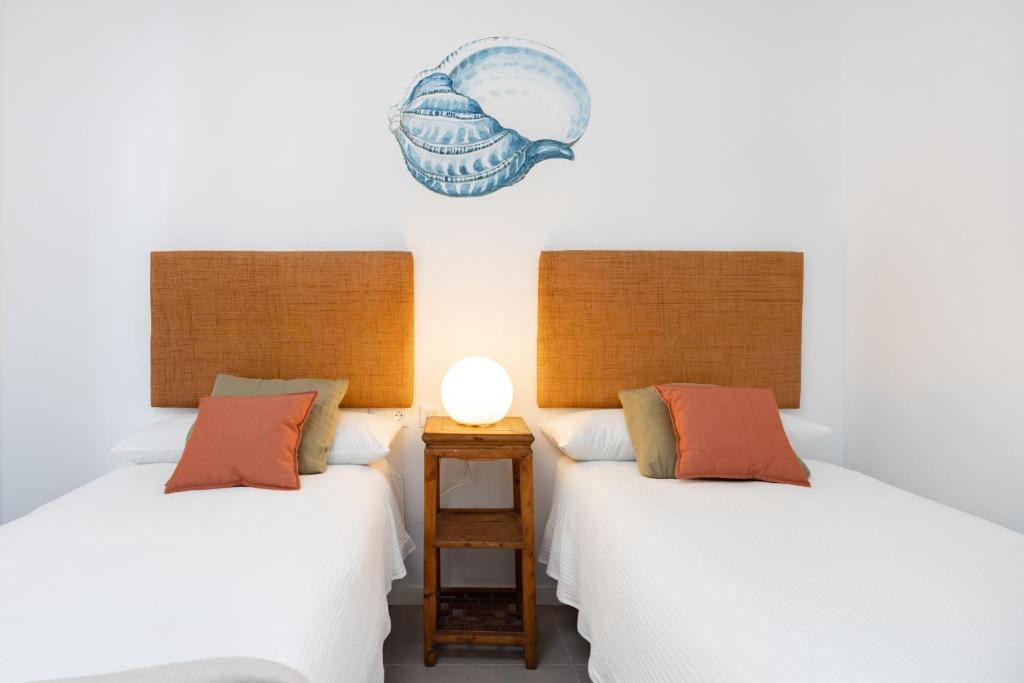 A bed or beds in a room at Home2Book Design & Breathtaking Sea Views El Porís
