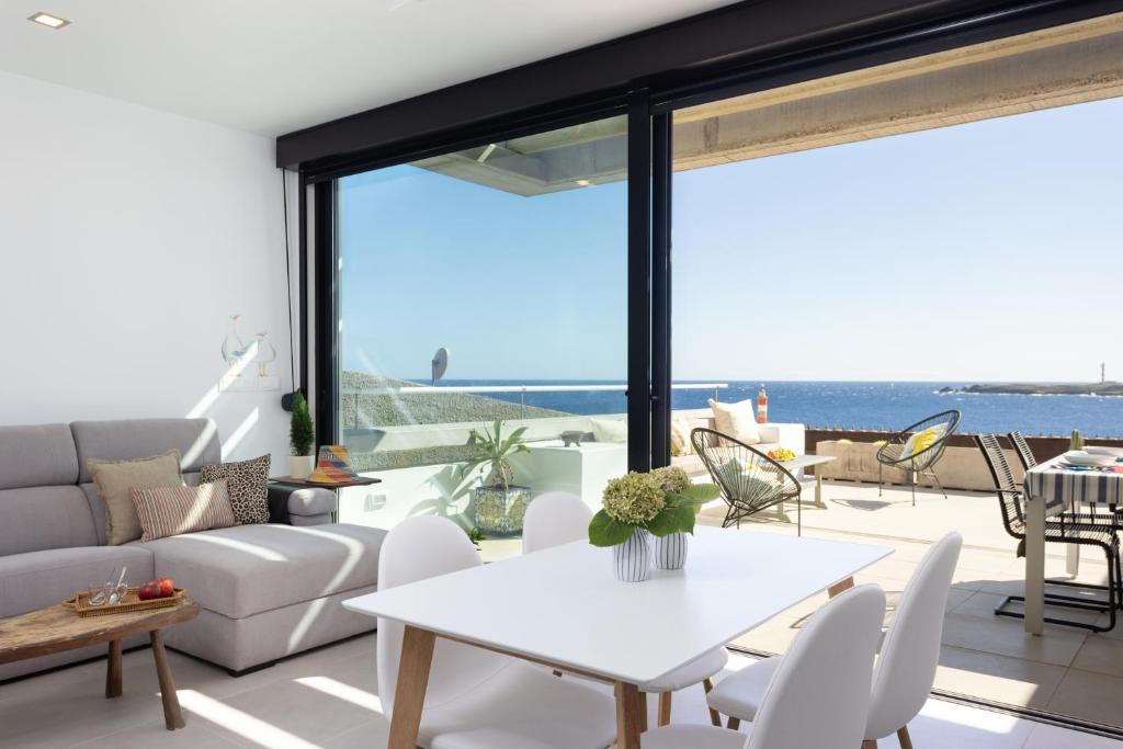 a living room with a white couch and a table at Home2Book Design & Breathtaking Sea Views El Porís in Poris de Abona