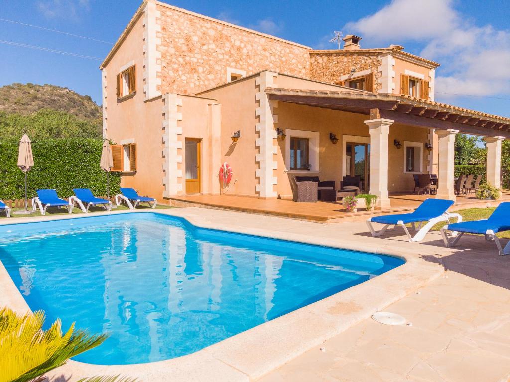 een villa met een zwembad voor een huis bij Finca Roca Blanca in S'Horta