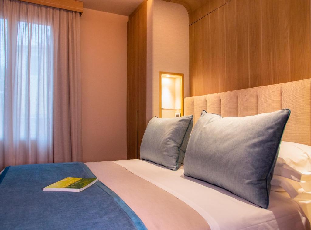 a hotel room with a bed with a book on it at Miramare Suites in Sestri Levante