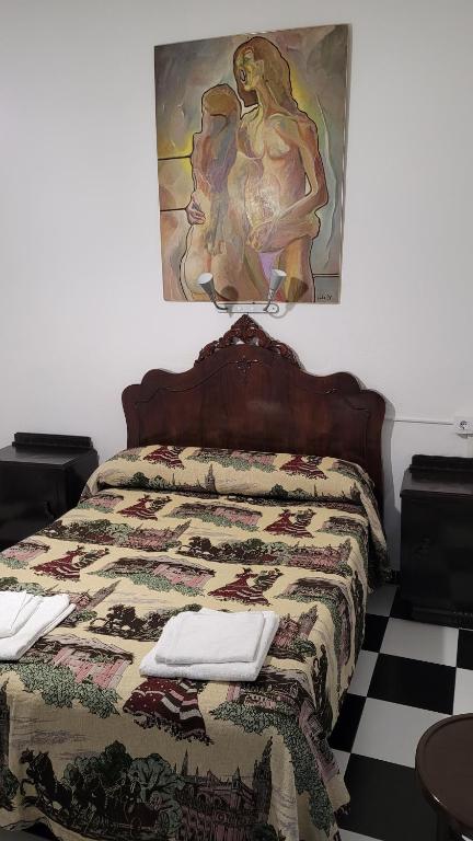 um quarto com uma cama com uma colcha em Pensión San Benito Abad em Sevilha