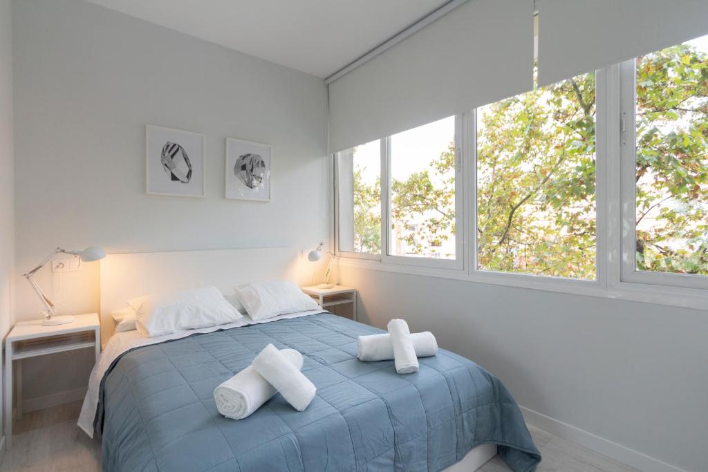 a bedroom with a blue bed with two white towels at Urbantec Realty - Plaza de Castilla in Madrid
