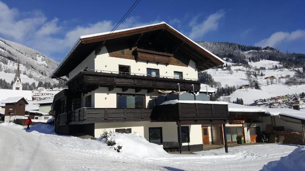 ein großes Gebäude mit Schnee auf dem Boden in der Unterkunft Woodyard in Piesendorf