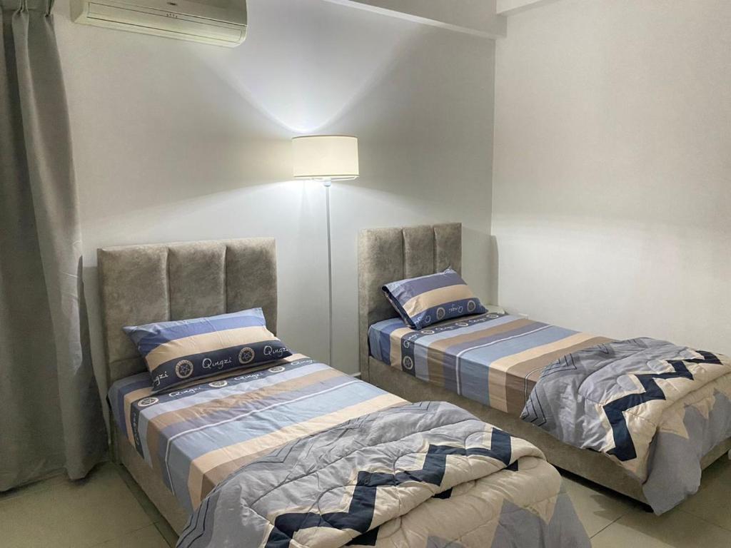 Postel nebo postele na pokoji v ubytování 休闲民宿 Leisure Homestay @The Venus Sitiawan