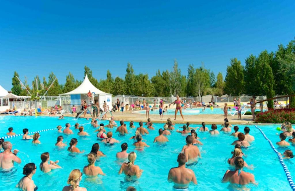 a large group of people in a swimming pool at Bungalow de 3 chambres avec piscine partagee et terrasse a Vias a 1 km de la plage in Vias