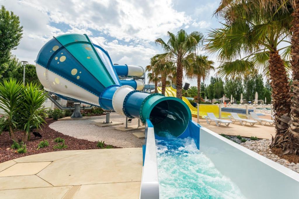 a water slide in a resort with a pool at Bungalow de 3 chambres avec piscine partagee et terrasse a Vias a 1 km de la plage in Vias