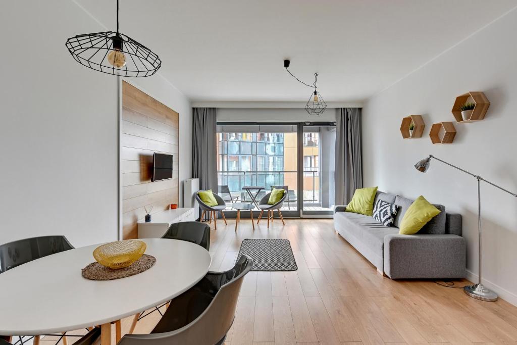 a living room with a table and a couch at Modern Old Town - Apartament w centrum Gdańska by Grand Apartments in Gdańsk