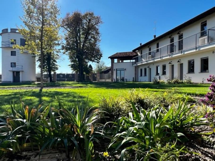 an exterior view of a white building with plants at Agriturismo Fattoria Primaluce - Appartamento Quercia in Spino dʼAdda