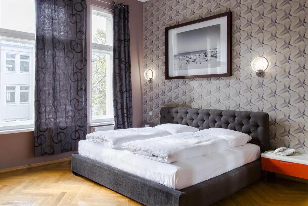 a bedroom with a large bed with a television on the wall at Hotel Residenz Begaswinkel in Berlin