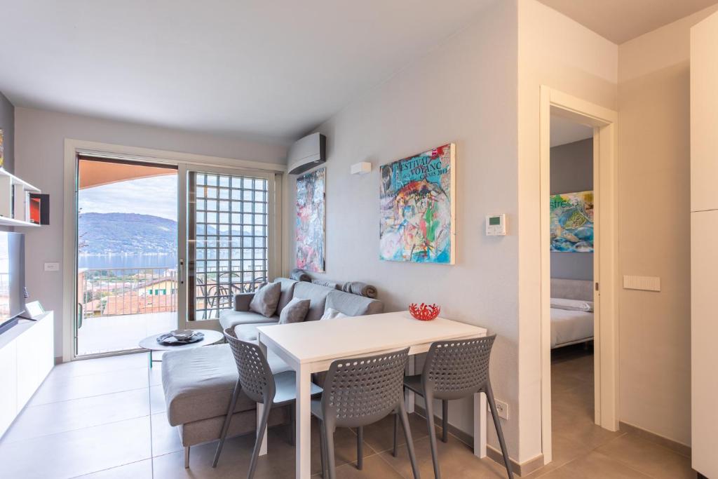 een woonkamer met een tafel en stoelen en een bank bij Le Terrazze Baveno in Baveno