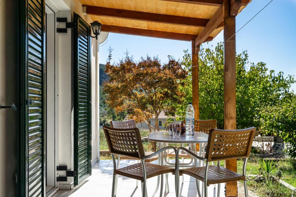a patio with a table and chairs on a porch at Pantelios Village apartment 1 in Kefallonia