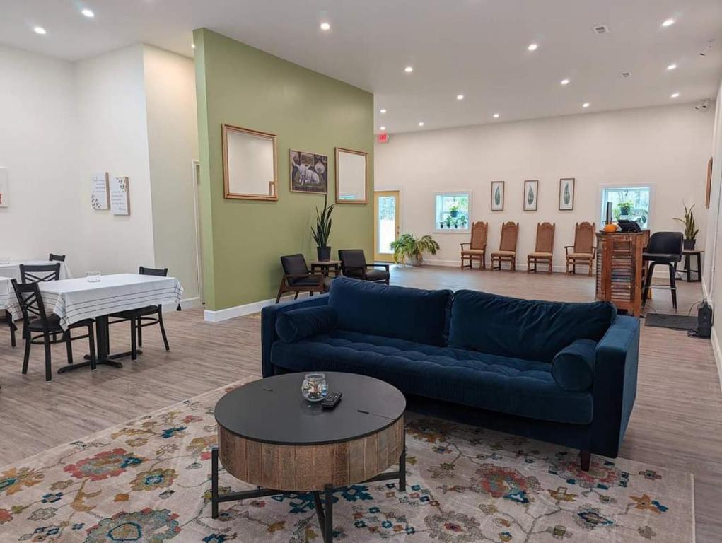 uma sala de estar com um sofá azul e uma mesa em The Honey Bee Motel em Dunlap