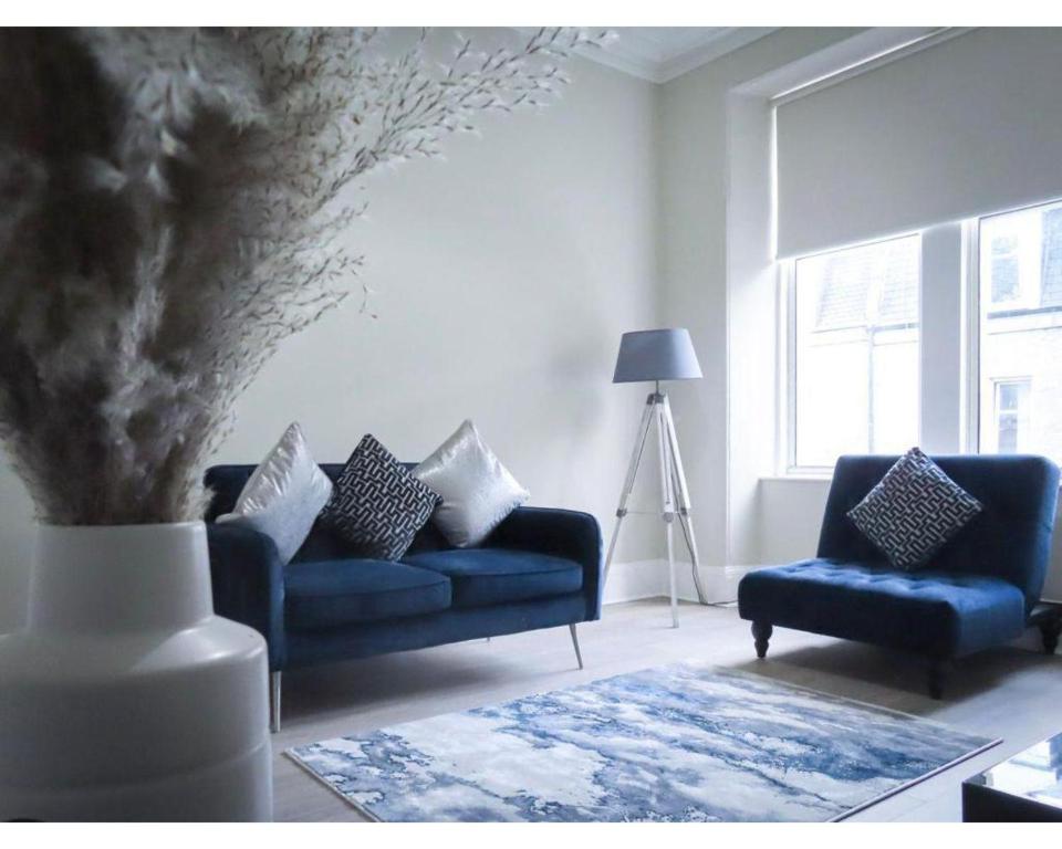 a living room with two blue couches and a vase at Strudel House - Luxury 1 Bed Apartment in Aberdeen City Centre in Aberdeen