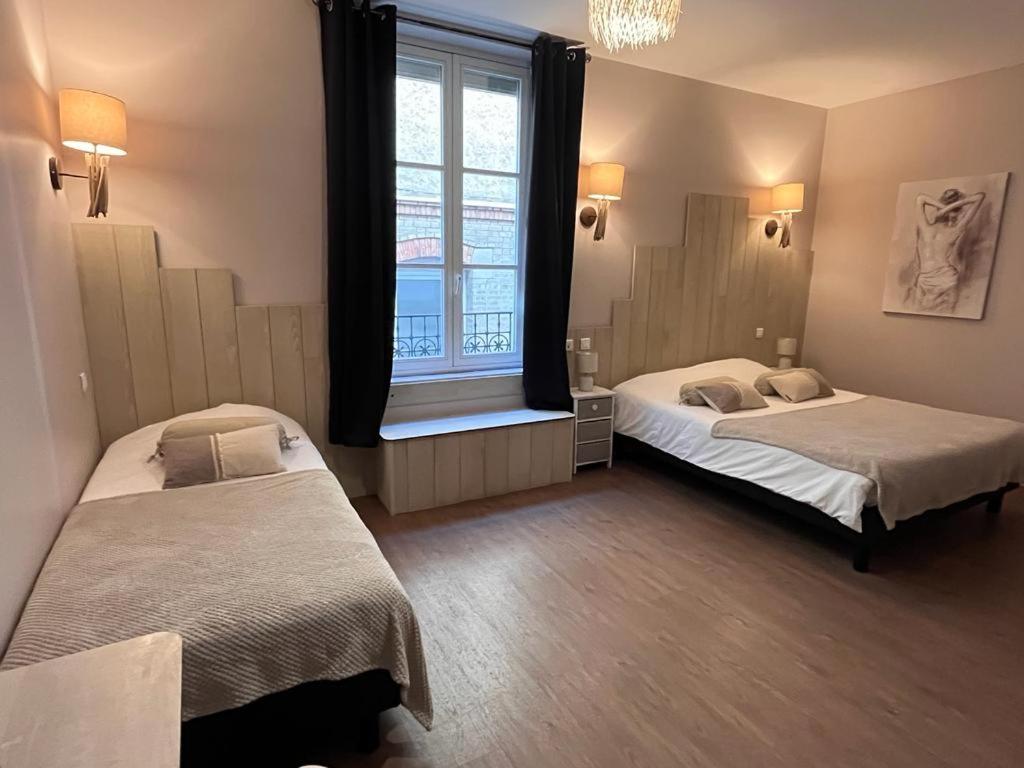 2 Betten in einem Zimmer mit Fenster in der Unterkunft Hotel du Pot d'Etain in Châlons-en-Champagne