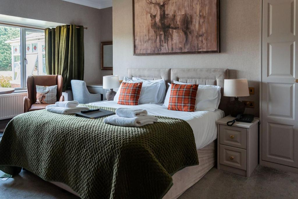 ein Schlafzimmer mit einem großen Bett und einem Fenster in der Unterkunft The Inn on the Moor Hotel in Goathland