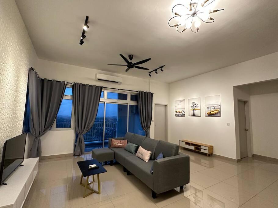 uma sala de estar com um sofá e uma ventoinha de tecto em AX Residence em Johor Bahru