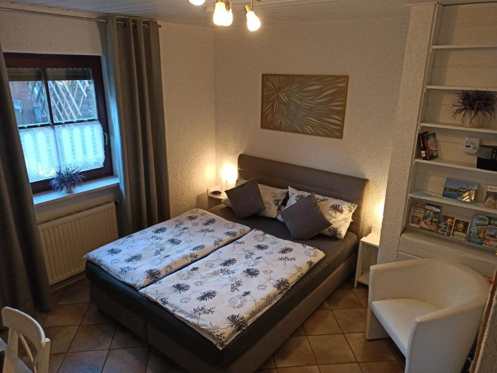 ein kleines Schlafzimmer mit einem Bett und einem Stuhl in der Unterkunft Gäste Apartement Casa Luber in Thalmassing