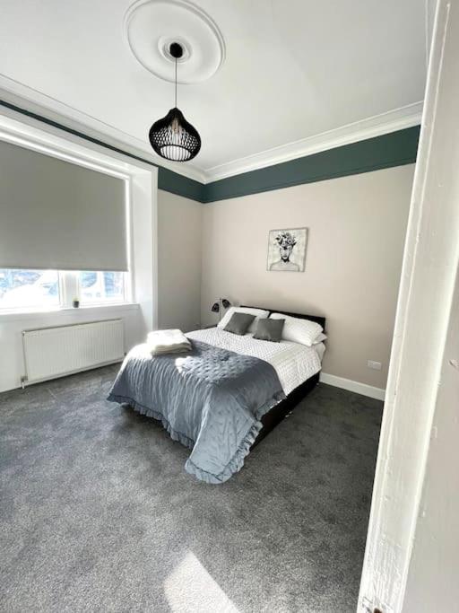 a bedroom with a bed and a large window at Stevenson Apartment in Alexandria