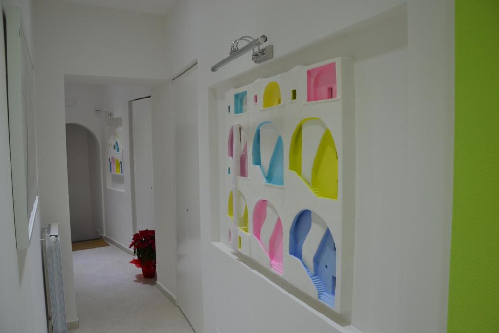 a hallway with colorful art on the walls at Terra Murata Boutique b&b in Procida