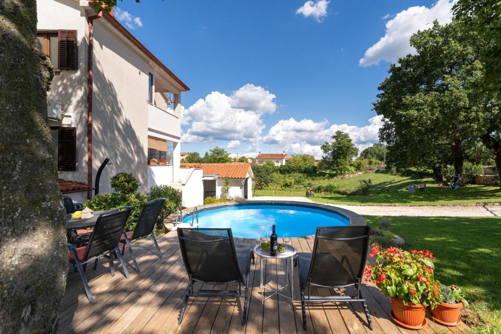 un patio con mesa y sillas y una piscina en Holiday apartment KALIĆ, en Štokovci